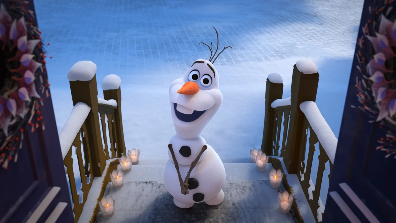 A digital 3D animation scene featuring Olaf, the friendly snowman from Disney's Frozen, standing outside on snow-covered wooden stairs. He looks up with a wide, joyful smile, big expressive eyes, and a prominent carrot nose, resting his twig hands together politely. The shot is framed from a high angle looking down out of an open doorway, with dark decorative doors and festive winter wreaths visible on both the left and right sides. Small, glowing candle lanterns line the sides of the snowy steps behind him, casting a warm light against the cool blue tones of the snow-covered ground.