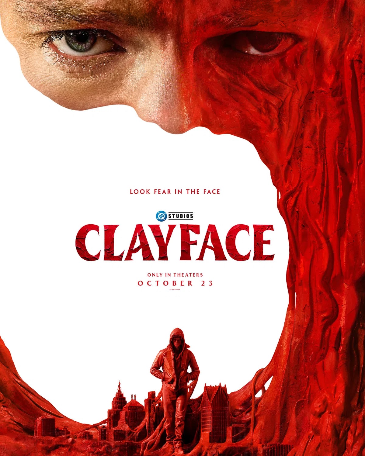 A striking movie poster for a film titled "Clayface" featuring a dramatic composition dominated by a large, close-up face split down the center. On the left side, a realistic human eye and smooth skin are visible, while the right side morphs into a swirling, textured, blood-red clay-like substance that forms a massive, gaping frame around the rest of the image. The title "CLAYFACE" is printed in a bold, stylized, red serif font in the center of the stark white background, accompanied by the tagline "LOOK FEAR IN THE FACE" above it and the "DC STUDIOS" logo. Below the title, the text reads "ONLY IN THEATERS" and "OCTOBER 23". At the bottom of the white space, a small, lone figure wearing a red hooded jacket and sunglasses stands amidst a jagged, miniature red cityscape formed by the swirling clay texture.