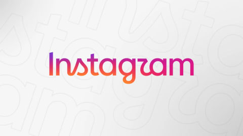 Social platforms rarely sit still for long, but their logos usually do. That changed this week for Instagram. Adam Mosseri, the platform's head, announced a fresh wordmark in a post shared to his own account. The update marks the first change to the lettering atop the app in ten years, according to Mosseri. An image displaying the official wordmark logo of the social media platform "Instagram" positioned prominently in the center against a minimalist light gray background. The text is rendered in its signature, elegant cursive script typeface, featuring fluid lines and distinctive rounded flourishes on letters like the 'g' and the 'm'. The wordmark is filled with a rich, continuous color gradient that starts with a deep purple on the left side of the initial capital letter 'I', blends seamlessly into a vibrant magenta and hot pink through the middle letters, and finishes with a bright, warm orange and red hue on the final letters 'am'. The background consists of a clean, off-white to light gray gradient with a subtle texture created by faint, oversized, and semi-transparent outlines of the platform's typographic elements layered softly behind the main text. These large, ghosted letters are cropped and overlapping, adding depth and visual interest to the composition without distracting from the main, vividly colored brand name in the foreground.