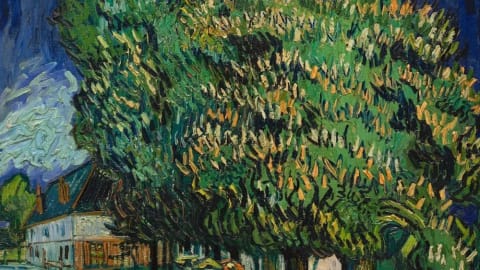 Blossoming Chestnut Trees by Vincent van Gogh is an oil painting from May 1890, depicting a dramatic street scene in Auvers-sur-Oise under a swirling, deep blue night sky dominated by towering green chestnut trees bursting with pale blossoms. On the left sits a rustic white house with a dark roof, while below the massive canopy, a group of figures with umbrellas gathers on a light-colored path near a lone walking man and a stone wall. The artwork showcases Van Gogh's signature Post-Impressionism style, characterized by thick, energetic impasto brushstrokes and a vibrant, emotionally charged color palette.