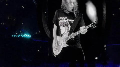 Metallica lead guitarist Kirk Hammett went viral for wearing a tongue-in-cheek "Taylor Swift Is A CIA Psyop" t-shirt on stage during the band's M72 World Tour. The unexpected crossover between the legendary thrash metal guitarist and the pop megastar quickly sparked widespread conversation across social media platforms like X, Reddit, and TikTok.