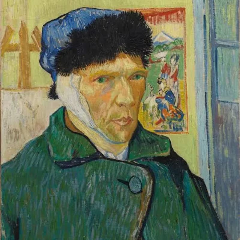 A close-up, medium shot of Vincent van Gogh’s 1889 oil painting Self-Portrait with Bandaged Ear depicts the artist facing slightly to the right, dressed in a heavy green winter coat and a blue fur-lined winter cap against a lime-green background. Van Gogh has pale skin, a gaunt face, sunken cheeks, light red hair visible along his brow line, and prominent green eyes that look directly forward with a serious, melancholic expression. A large, thick white bandage is securely wrapped under his chin and around his right ear. To his right, an open blue door frame reveals a sliver of darkness, while to his left, an unfinished canvas sits on an easel next to a Japanese ukiyo-e woodblock print pinned to the wall, which features figures in kimonos against a landscape with Mount Fuji. The painting is executed in Van Gogh's signature Post-Impressionist style, featuring thick, visible, and highly textured impasto brushstrokes throughout the composition.