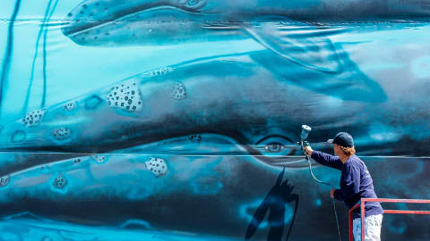 Laguna Beach artist, Wyland, one of the best-known marine-life painters in the country, recreates the first of his 100 whaling walls on a giant canvas adjacent to his gallery in Laguna Beach on Monday, July 15, 2019, 38 years after he first painted the mural on the Hotel Laguna. (Photo by Leonard Ortiz, Orange County Register/SCNG)