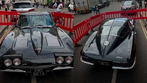 A vintage black 1963 Chevrolet Corvette Sting Ray Coupe with custom UK registration plates is cordoned off by red barriers during the outdoor street filming of The Batman Part II. Bruce Wayne’s classic civilian ride is back on the streets for director Matt Reeves' upcoming DC sequel. Newly leaked images from the London production set of The Batman Part II reveal a flawless, gloss-black 1963 Chevrolet Corvette C2 Sting Ray Split-Window Coupe parked behind red security barricades. This distinct vintage vehicle, sporting the Gotham registration plate XMC 867A, serves as the personal transportation of Robert Pattinson’s Bruce Wayne. It mirrors the exact classic model he drove in the 2022 film during the city hall funeral sequence, emphasizing the character's preference for grounded, unbadged, "old money" muscle rather than ostentatious modern supercars.