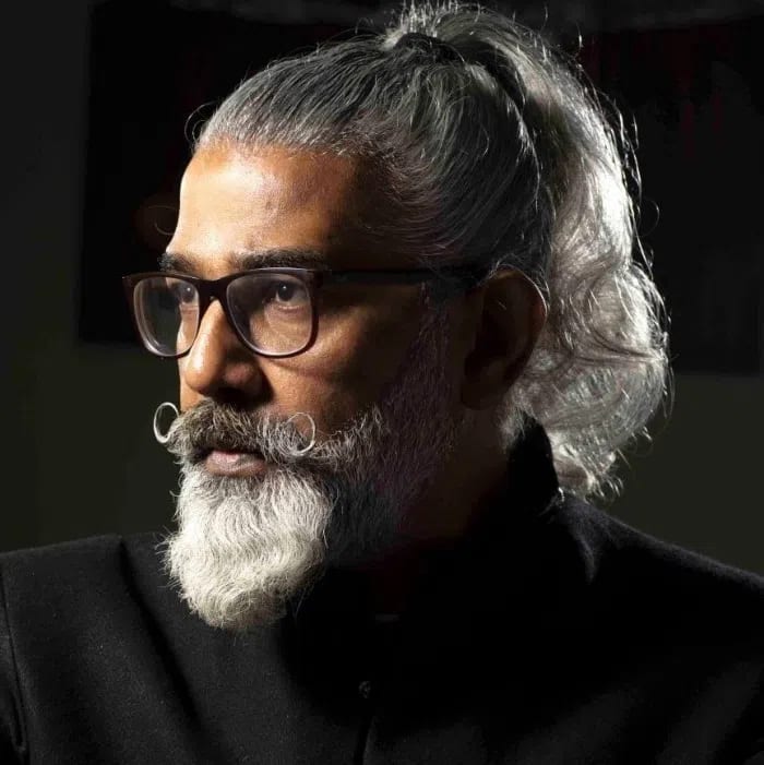 R.M. Naeem is a prominent Pakistani contemporary painter, curator, and art educator who has significantly shaped the South Asian art landscape. Born in Mirpurkhas, Sindh, in 1968, he later graduated with distinction from the National College of Arts (NCA) in Lahore in 1993. He joined the NCA permanent faculty the following year and was recognized as an Associate of NCA in 2019. In 2023, the Government of Pakistan awarded him the prestigious President's Pride of Performance for his outstanding contributions to the visual arts.His distinctive artistic style blends high-fidelity realism with surrealist elements to critique contemporary social paradigms and extremism. He often merges traditional Mughal miniature aesthetics with modern digital-age imagery, such as digital glitches. A signature motif in his work is the depiction of smooth, sculpted, gender-neutral shaven heads paired with organic elements like water, mountains, and trees to evoke calm, meditative states and explore deep themes of collective responsibility and spirituality.Beyond his studio practice, Naeem is a dedicated mentor who established Studio RM in Lahore in 2008. This independent space hosts an international artist residency program that fosters global cross-cultural dialogue and collaboration. Over his three-decade career, Naeem has held more than 20 solo exhibitions and participated in major international events, including the India Art Fair, the Asian Art Biennale in Bangladesh, Asia Now Paris, and the Karachi Biennale. His artwork is featured globally on major platforms like Saatchi Art and locally through premier galleries like O Art Space.